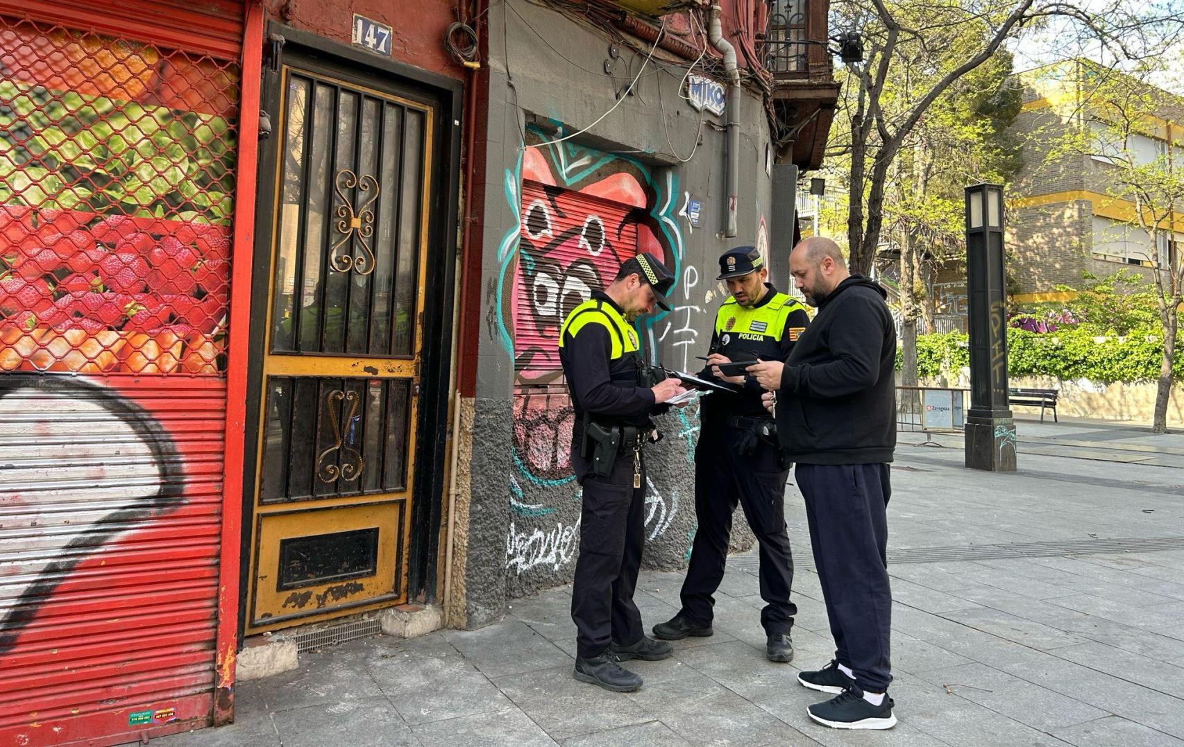 Uno de los vecinos, junto a la Policía Local de Zaragoza, volviendo a casa.