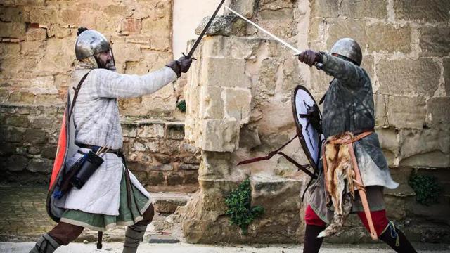 Dos caballeros luchando con espadas.