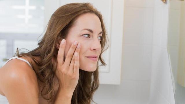 Mujer mirándose frente al espejo.