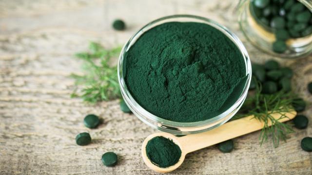 Comprimidos de espirulina y polvo en cuenco.