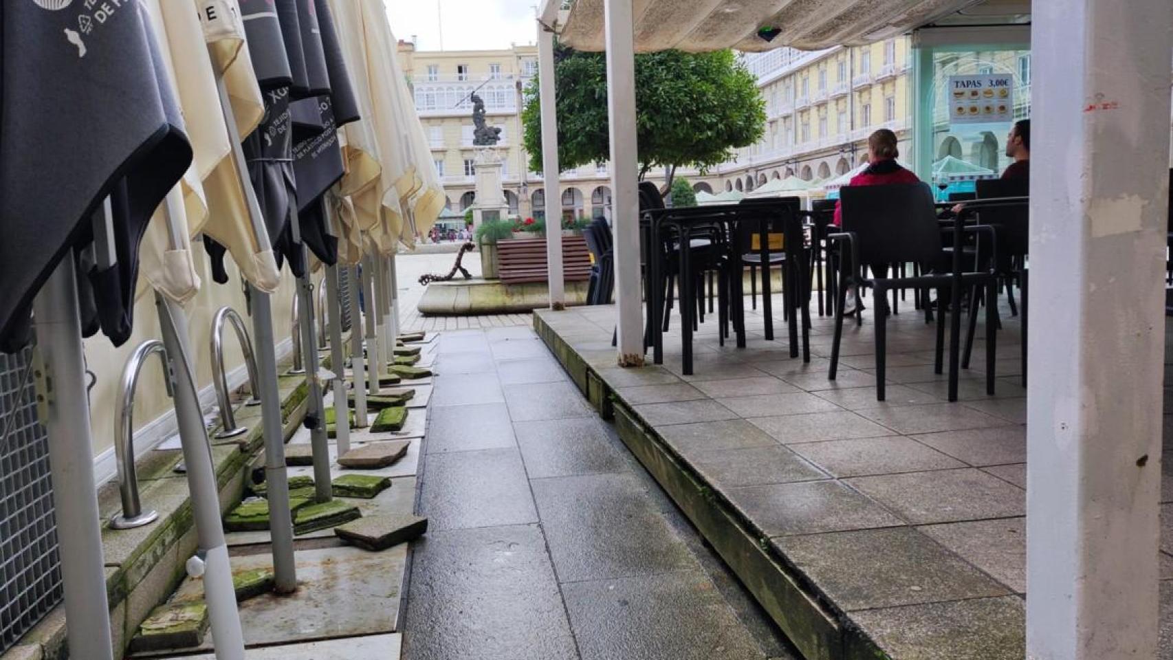 Sombrillas y un lateral abierto de una terraza acristalada de la plaza de María Pita en A Coruña.