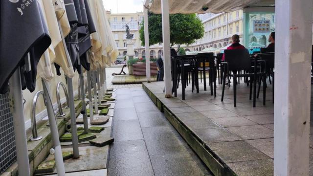 Sombrillas y un lateral abierto de una terraza acristalada de la plaza de María Pita en A Coruña.