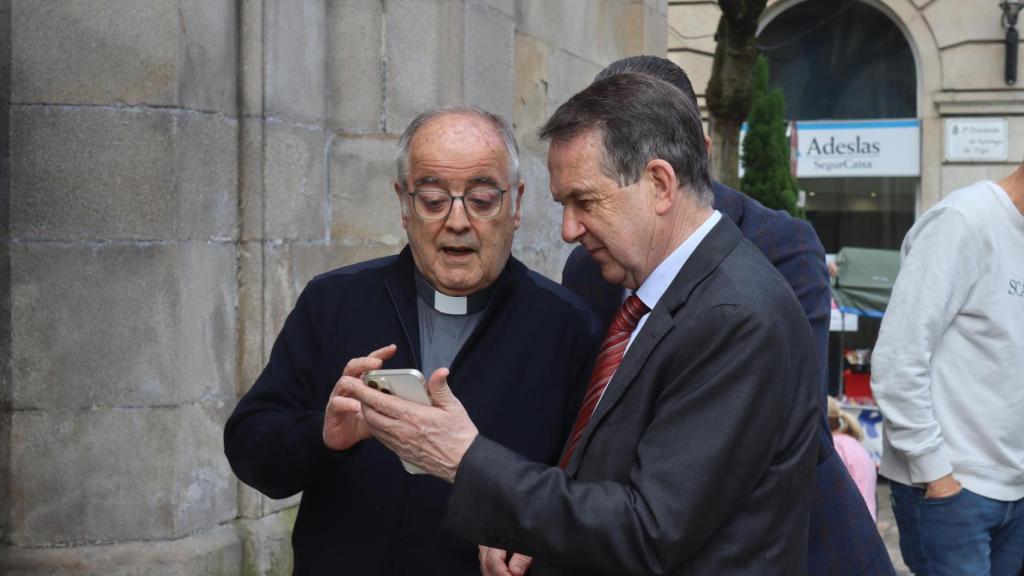 Caballero observando en el móvil del párroco de la iglesia de Santiago de Vigo fotos de la nueva iluminación por la noche