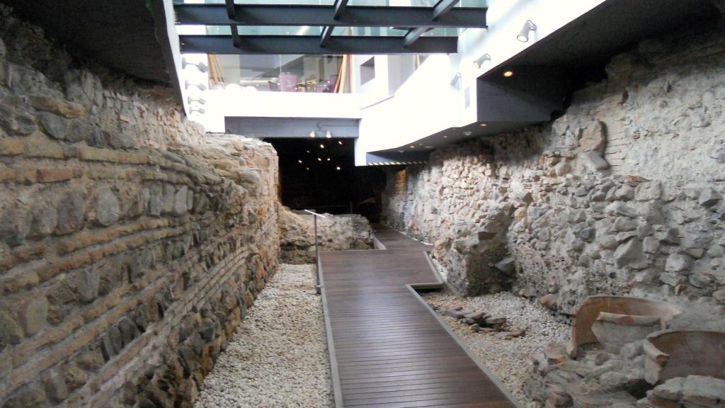 Integración de la muralla medieval y paso de ronda en el sótano de un hotel.