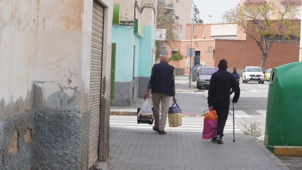 Dos vecinos saliendo de sus casas en el barrio de San Antón.