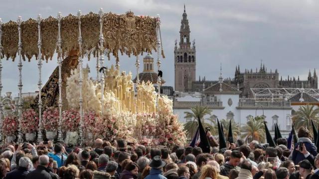 Miles de fieles siguen a La Esperanza de Triana a su paso sobre el río Guadalquivir de Sevilla.