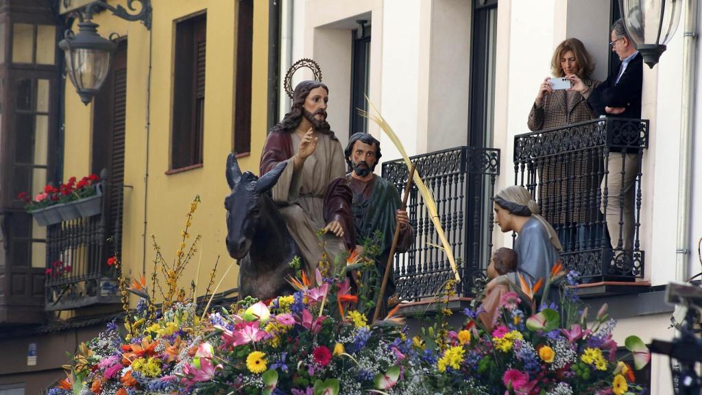 Miles de personas acompañan al paso de La Borriquilla en la procesión de las Palmas de León