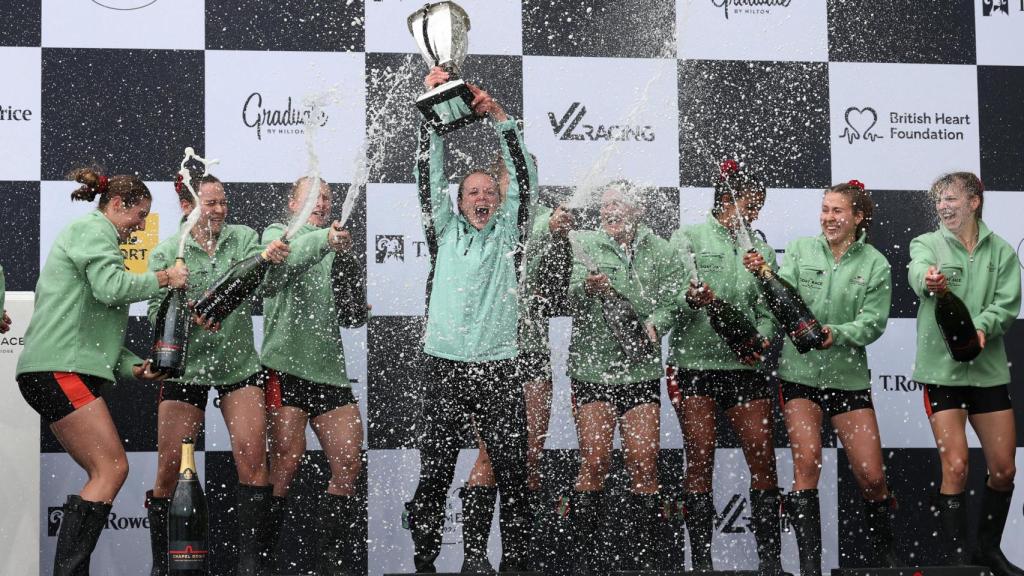 El equipo femenino de Cambridge celebra la victoria en el podio tras ganar la regata.