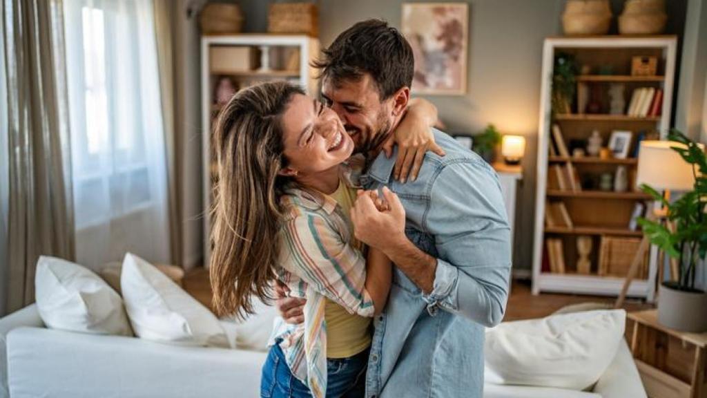 Pareja riendo mientras baila en el salón.