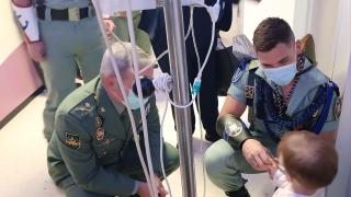 Legionarios saludan a un pequeño ingresado en el Materno en Málaga.