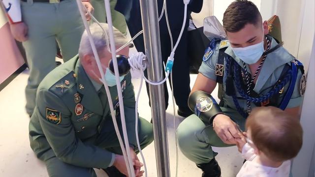 Legionarios saludan a un pequeño ingresado en el Materno en Málaga.