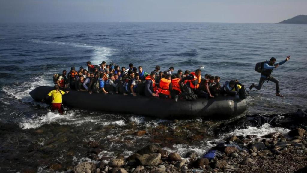 Un migrante afgano salta de una balsa abarrotada a una playa en la isla griega de Lesbos el 19 de octubre de 2015.