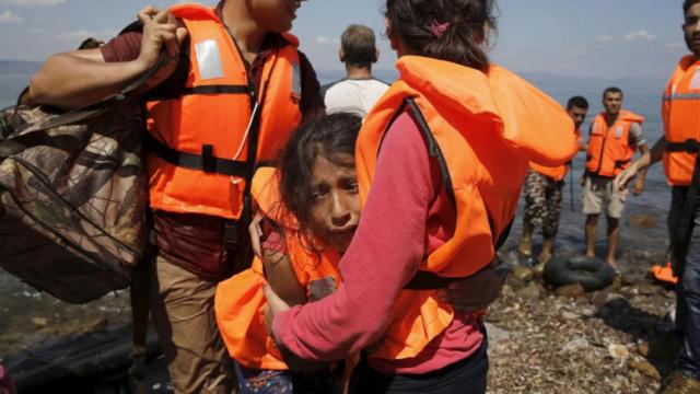 Una niña refugiada siria de Kobane llora mientras abraza a otro refugiado, momentos después de llegar con otros refugiados sirios en un bote a la isla de Lesbos, Grecia, el 23 de agosto de 2015.