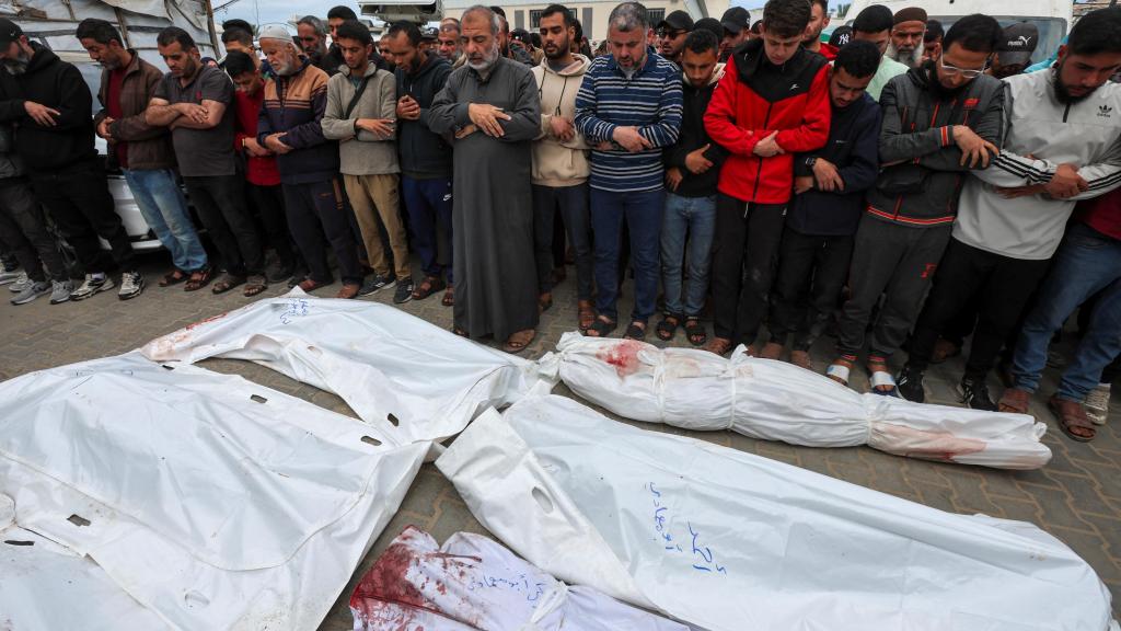 Un padre reza este lunes ante los cadáveres de sus seis hijos tras un ataque de Israel en Gaza.