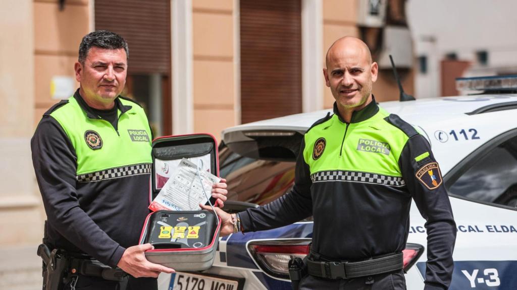 Los agentes de la Policía Local de Elda junto al desfibrilador con el que salvaron la vida al trabajador.