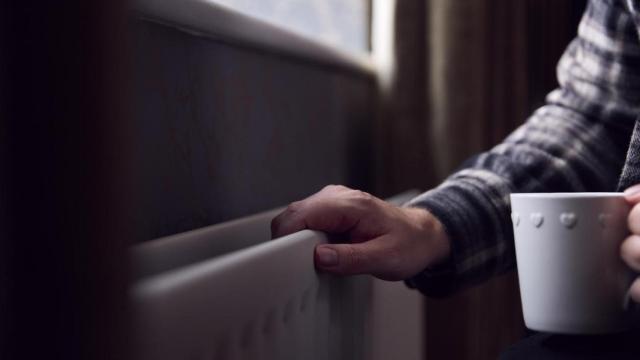 Una persona tocando el radiador.