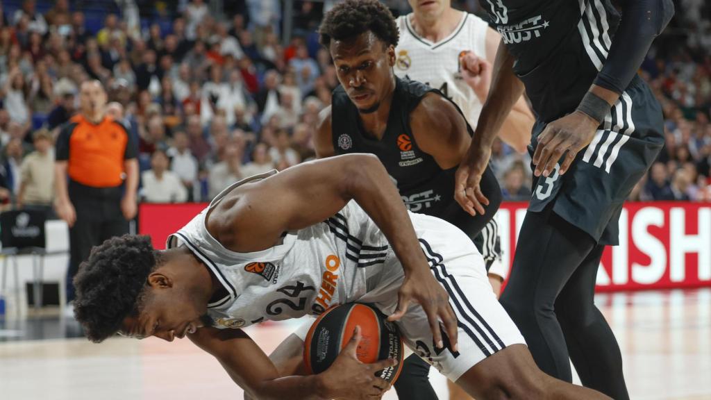 Andrés Feliz trata de guardar la posesión para el Real Madrid.