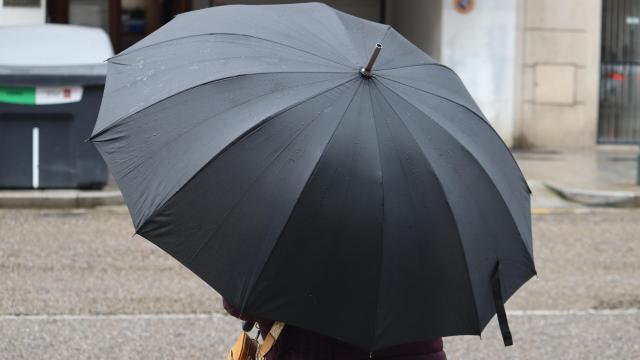 Una vecina de Vigo cubriéndose con un paraguas de la lluvia