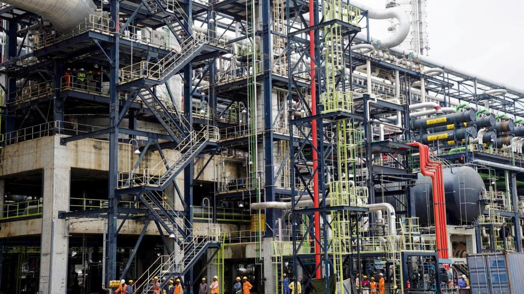 Los trabajadores se paran frente a la Unidad de Hidrocraqueo Suave (MHC) en la Refinería de Petróleo Dangote en Lagos, Nigeria, el 20 de julio de 2024.