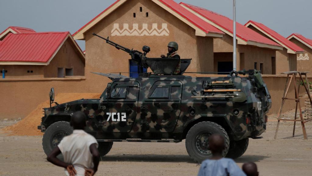 Un vehículo blindado de las Fuerzas de Seguridad Nigerianas pasa por casas recién construidas, antes de la ceremonia de reapertura de la comunidad que fue destruida por militantes armados de Boko Haram en 2015, en Ngarannam, estado de Borno, Nigeria, el 21 de octubre de 2022.