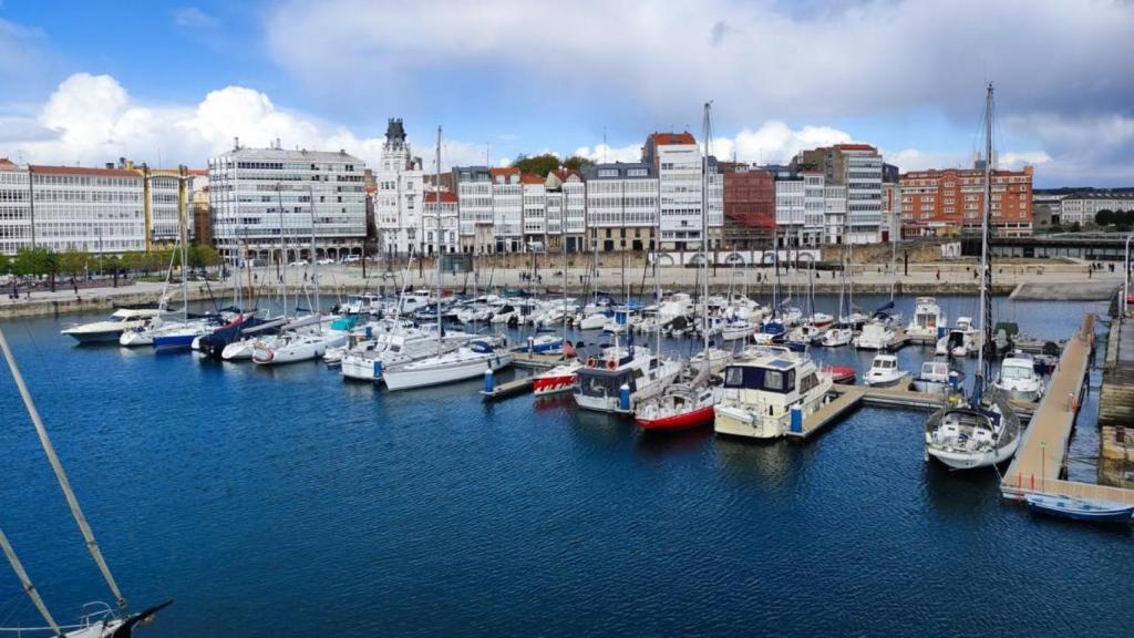 Pantalanes con embarcaciones del Naútico, con O Parrote al fondo.