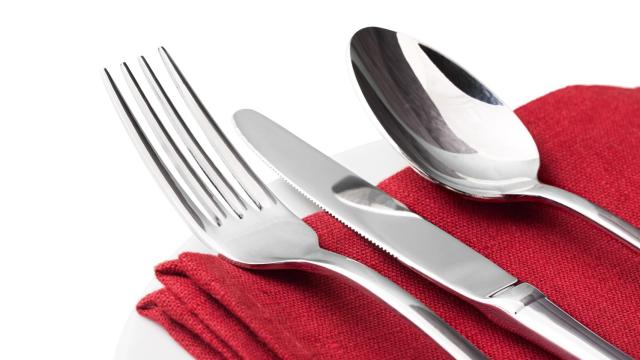 Unos cubiertos de plata sobre una servilleta roja.