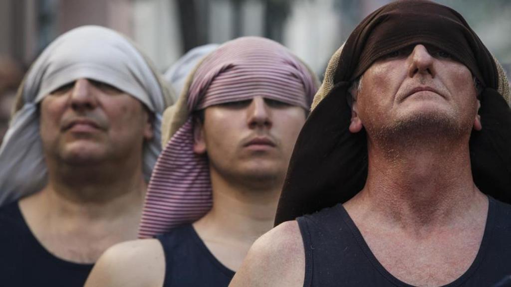 Varios costaleros preparados para llevar un paso.