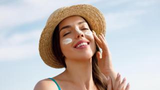 Una mujer se aplica protector solar en el rostro