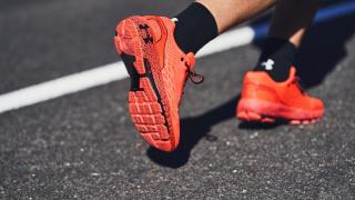 Un corredor con zapatillas y calcetines de Under Armour.