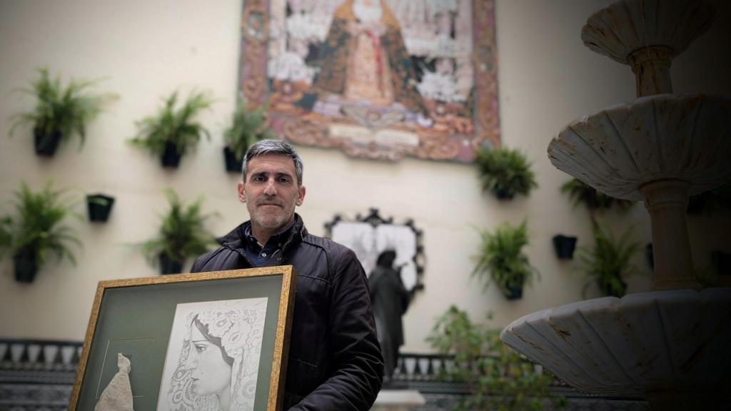 Una imagen de Raúl, con el cuadro con el pañuelo que le recuerda su 'milagro' junto a su Virgen de la Esperanza.