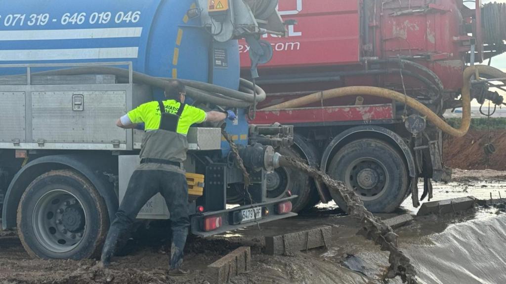Un operario vuelca lodo en las balsas habilitadas para su almacenamiento. EE