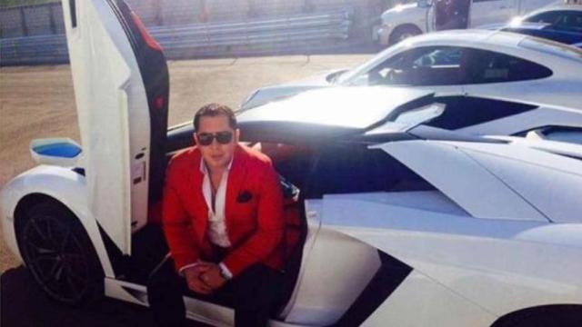 Raúl Batres, posando con uno de sus coches de lujo.