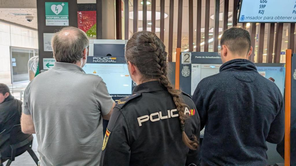 Dos usuarios en la comisaría de Alicante registrando su DNI para tener el acceso a la versión móvil.