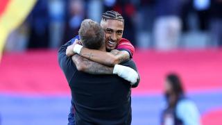 Raphinha y Hansi Flick se abrazan.