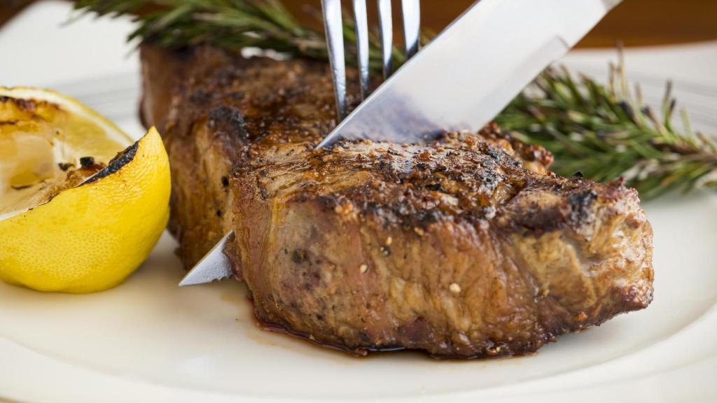 Alguien cortando un trozo de carne