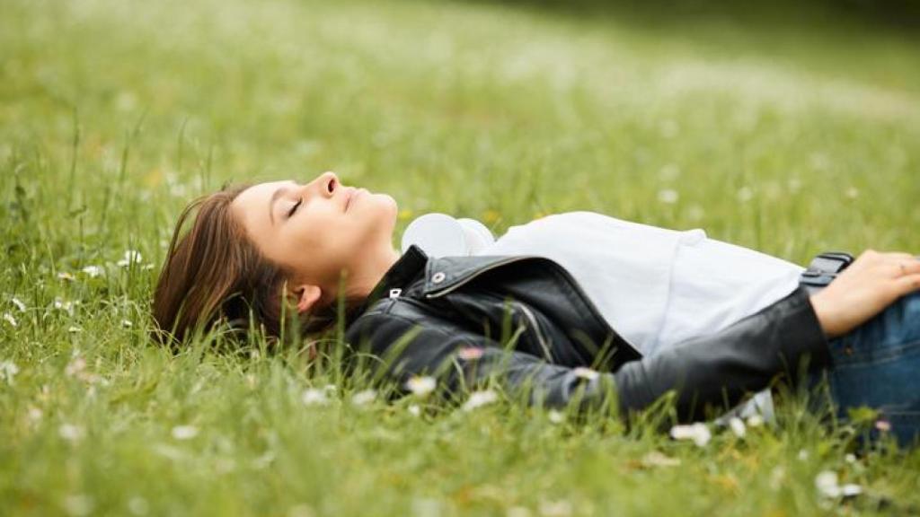 Mujer descansando sobre la hierba.