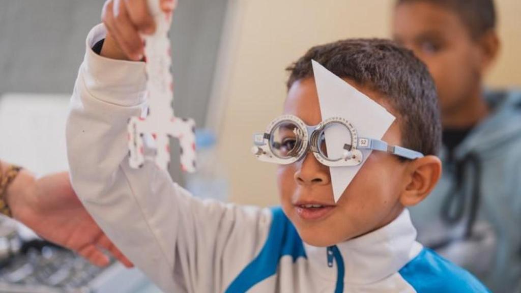 Niño utilizando la cartulina para comunicarse con la voluntaria.