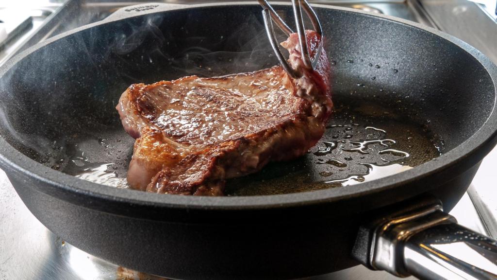 Un filete cocinándose en la sartén.