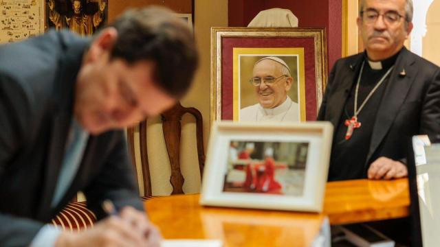 El presidente de la Junta, Alfonso Fernández Mañueco, durante la firma del libro de condolencias por la muerte del Papa Francisco en el Arzobispado de Valladolid, en presencia del arzobispo y presidente de la Conferencia Episcopal Española, Luis Argüello, este martes
