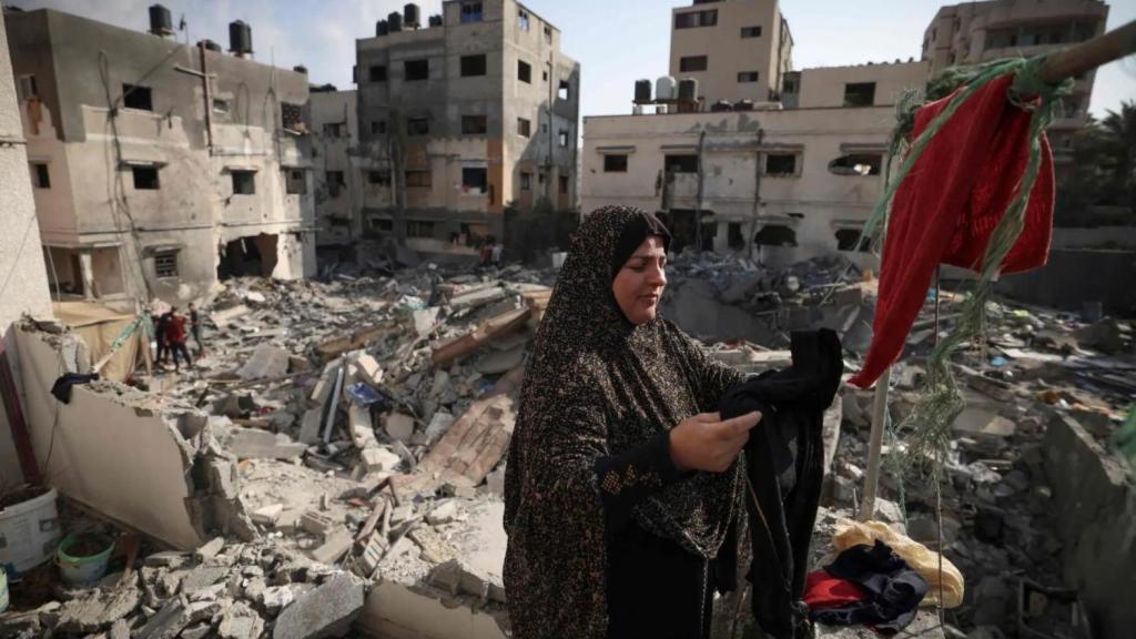 Una mujer palestina cuelga la ropa recogida entre los escombros de su casa en la ciudad de Gaza.