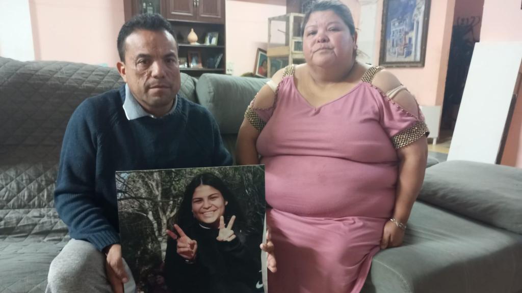 Patricio, sujeta un retrato gigante con la siempre sonriente Claudia,  junto a su esposa, Carmen, en el salón de su casa en Totana.