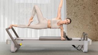 Una persona utilizando el equipo de pilates Technogym Reform.