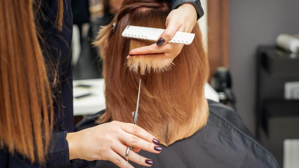 Mujer cortándose el pelo.