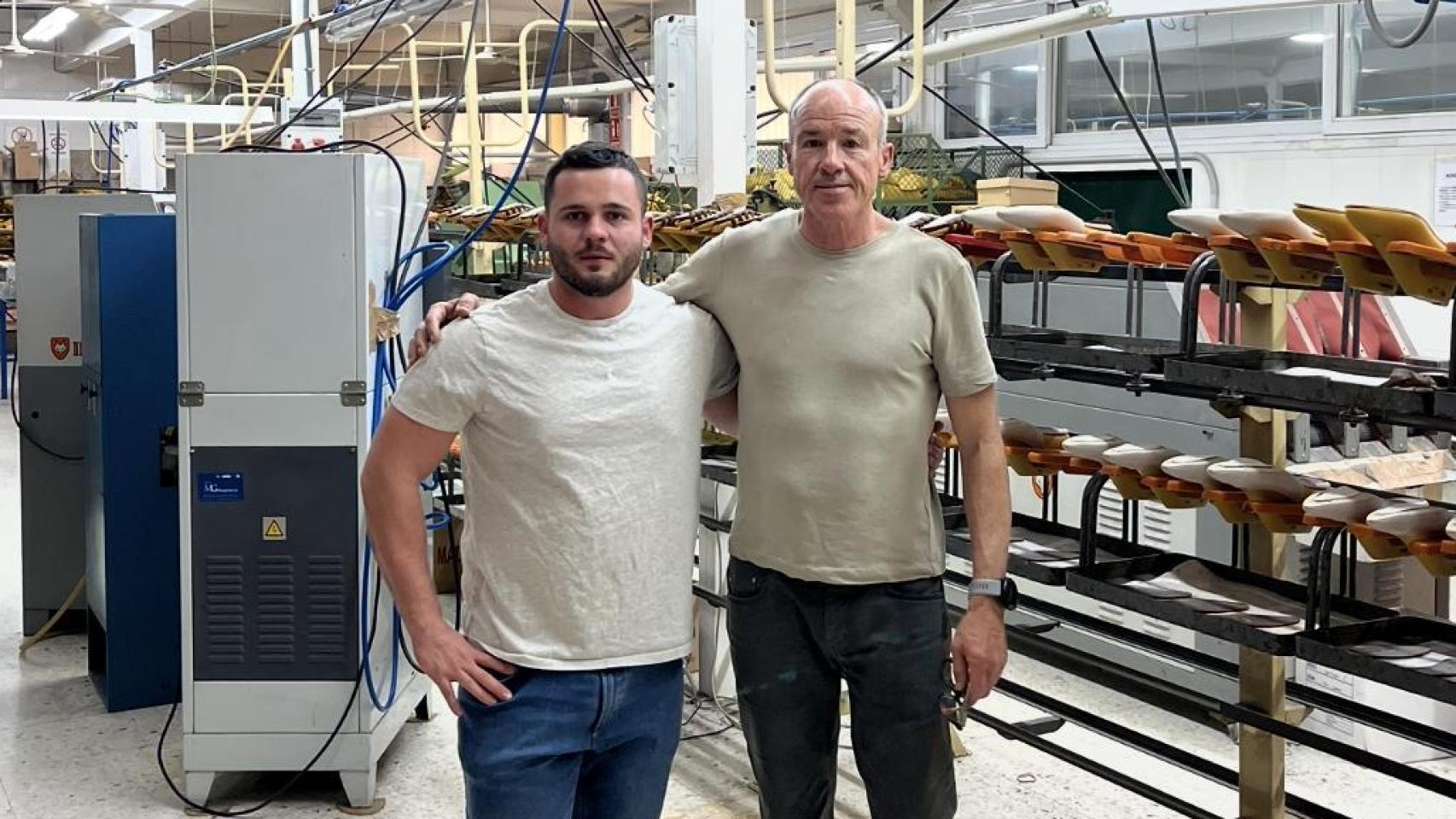 Padre e hijo posan en la fábrica de calzado en la que trabajan.