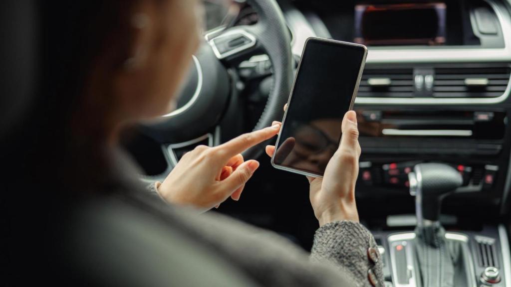 Una conductora utiliza el teléfono móvil