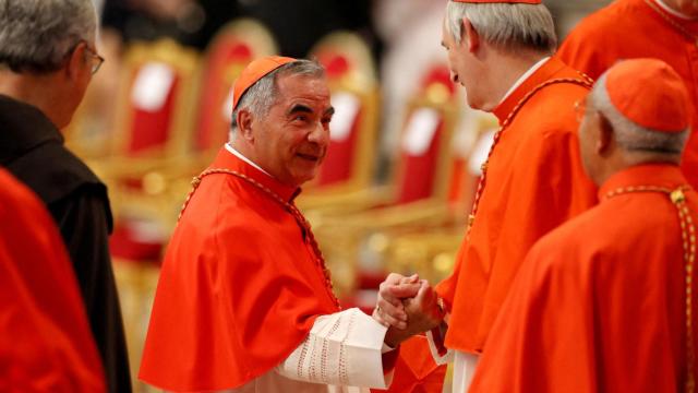 El cardenal Angelo Becciu saluda al cardenal Matteo Zuppi durante una ceremonia.