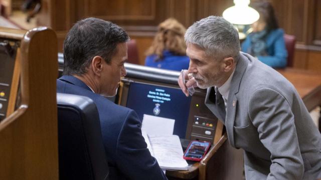 Pedro Sánchez dialoga en su escaño con Marlaska, en el Congreso de los Diputados.