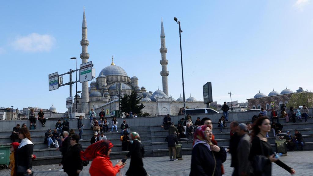 La gente camina en el distrito de Eminonu, con la Nueva Mezquita de fondo, tras el terremoto en Estambul.