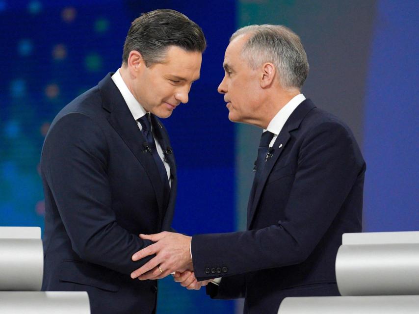 El líder conservador Pierre Poilievre y el líder liberal Mark Carney se dan la mano mientras conversan después del debate federal de líderes en inglés en Montreal, Canadá, el jueves 17 de abril de 2025.