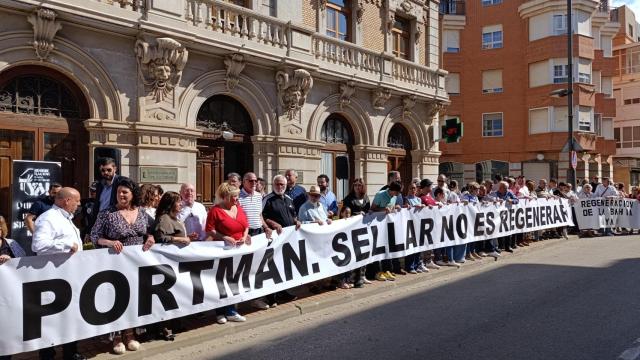 Representantes políticos y vecinos de La Unión despliegan una pancarta contra el proyecto de sellado anunciado por el MITECO.